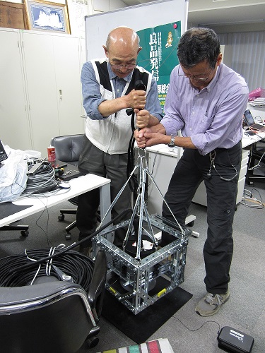 機械工作班長 熊谷 訓行様（左）と電気工作班長 山田 次郎様
（右）に 測定に使用する検出器ケージを見せて頂きました。